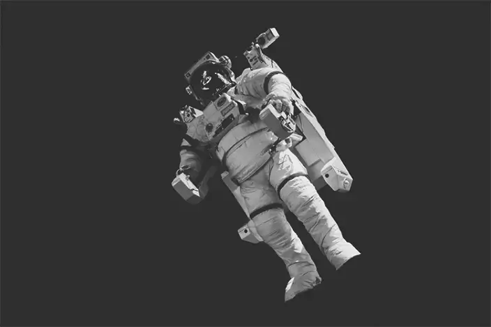 Eine Person, die einen Raumanzug trägt und im Weltraum schwebt.